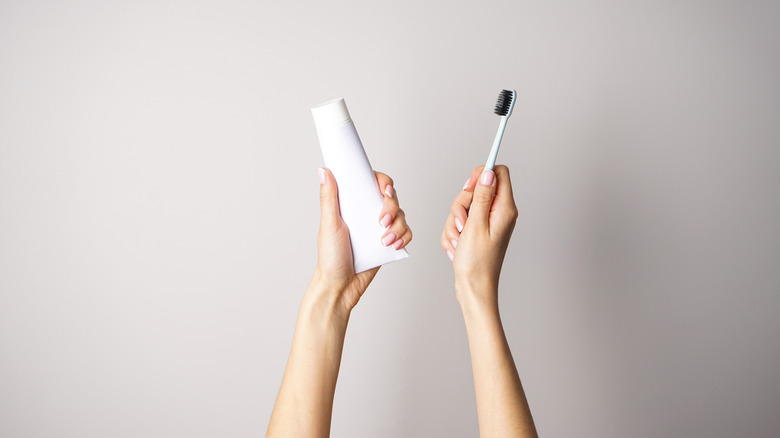 Woman holding toothpaste and toothbrush