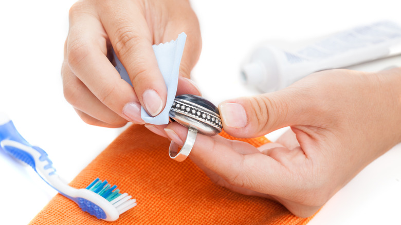 Woman cleaning jewelry with toothpaste