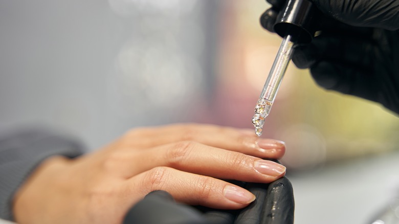 Nail tech applying oil to nails