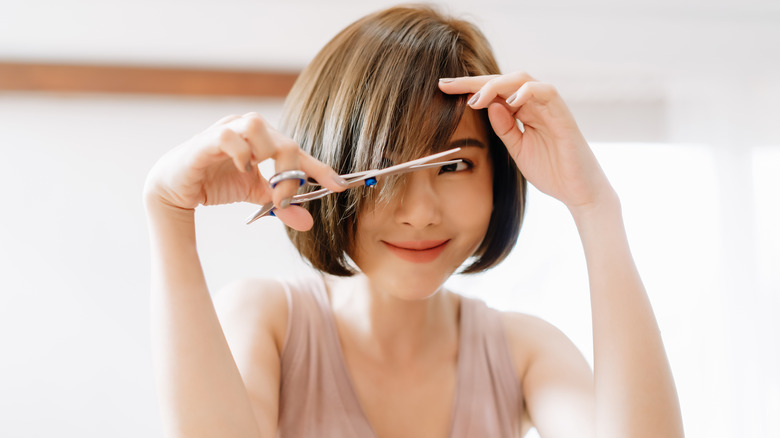 woman smiling cutting her bangs