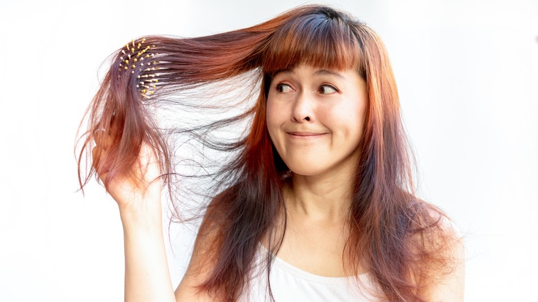 Woman brushing messy brown hair