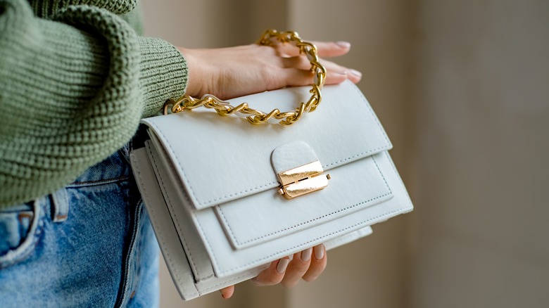 Woman holding a white leather handbag