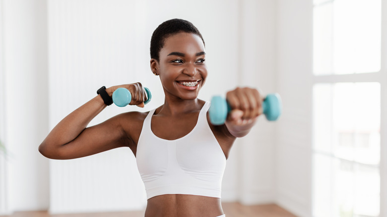 A woman working out with small weights 