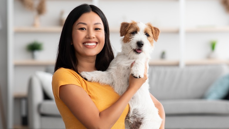 woman happily holding a dog. 