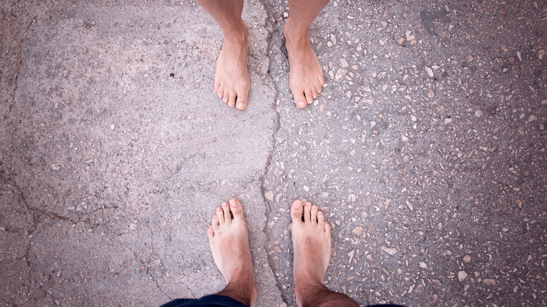 Couple's feet on cracked earth