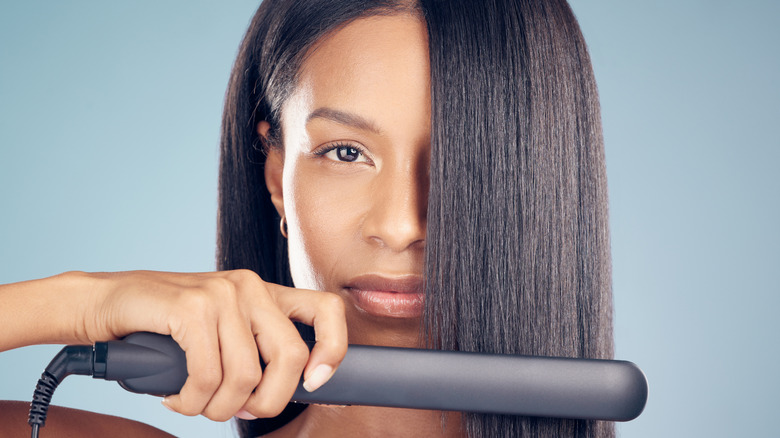 Woman using flat iron