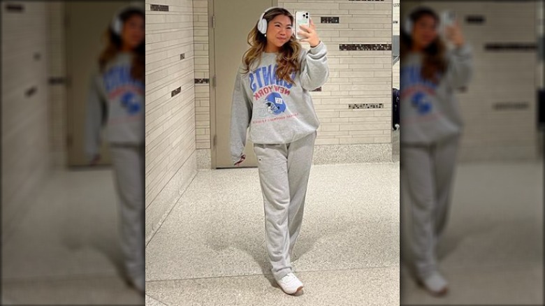 Woman taking mirror selfie wearing sweatsuit