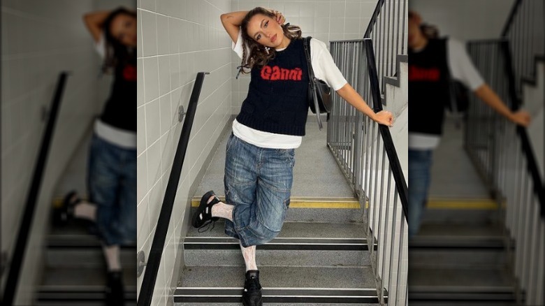 woman posing in jorts and sweater vest