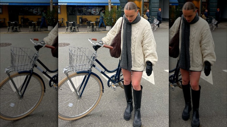 woman holding bike in oversized sweater