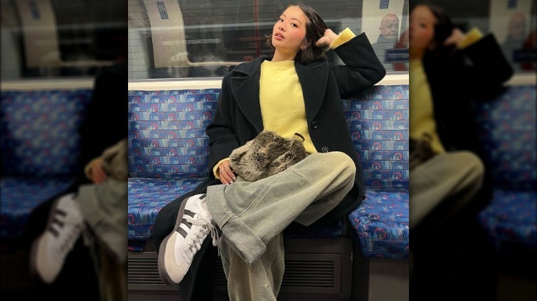 woman in cross-legged pose on subway