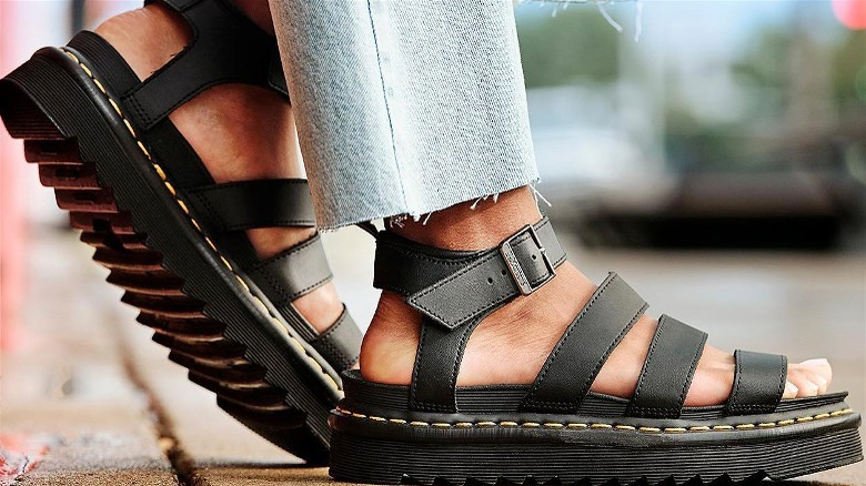 Person wearing jeans and black strappy sandals