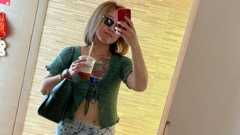 Woman taking mirror selfie with iced coffee