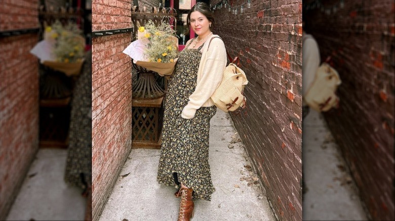 Noelle Downing in an alley with flowers