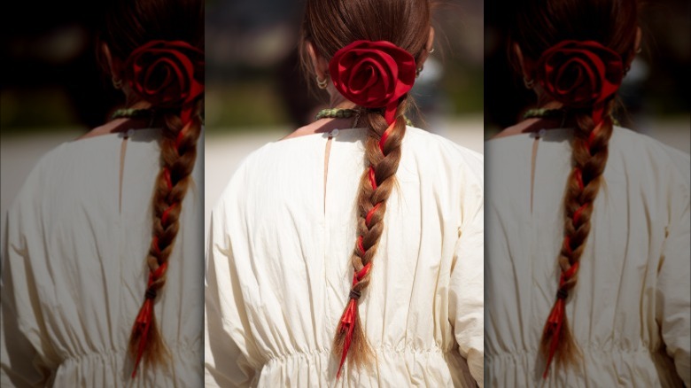 A woman with a rose and ribbon in her braid