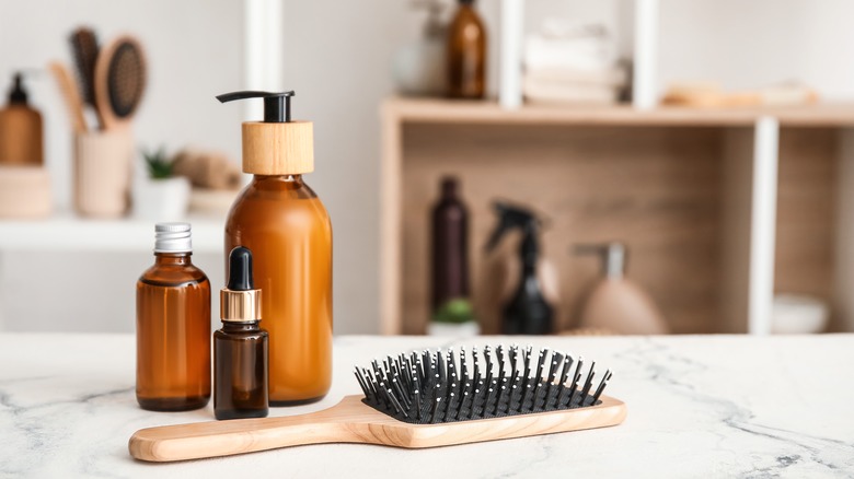 Hairbrush and hair products on a marble countertop