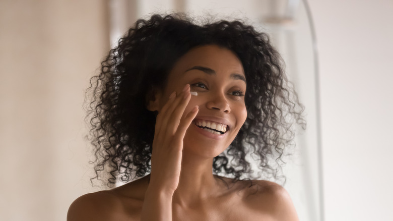 A woman applying cleanser on her face 