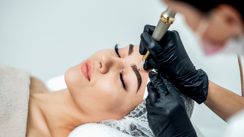 Woman undergoing eyebrow tattoo