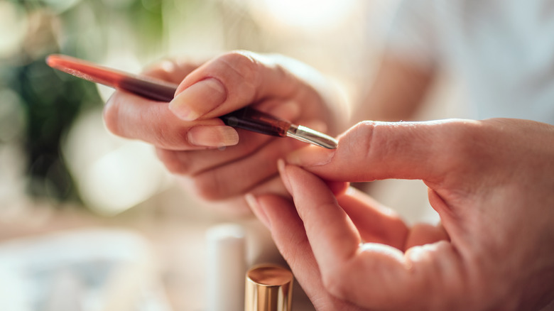 woman using metal cuticle pusher