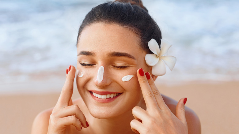 Woman applying sunscreen on the beach