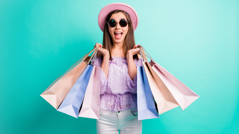 A woman holding pastel colored shopping bags