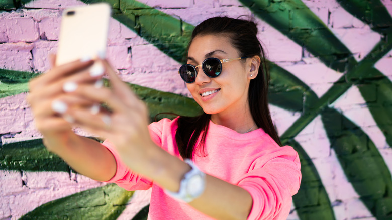 Influencer taking a photo in front of a mural