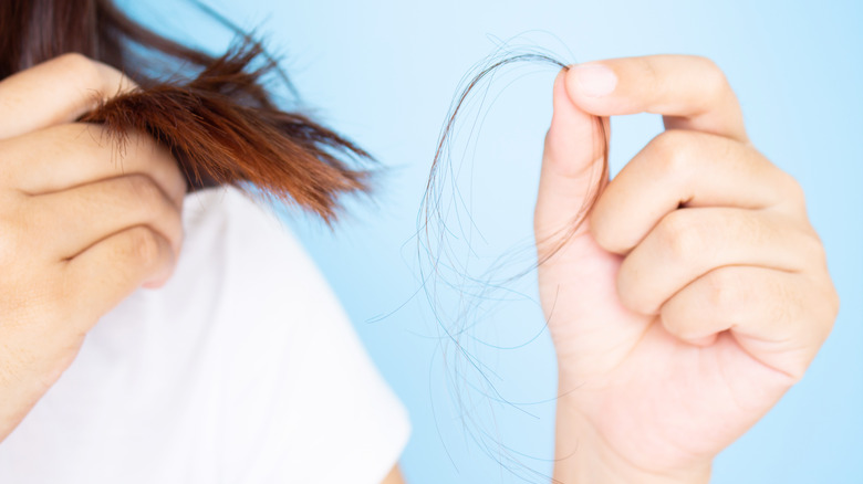 Woman holding a few strands of her hair