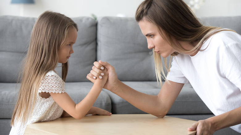 Mother and daughter arm wrestling