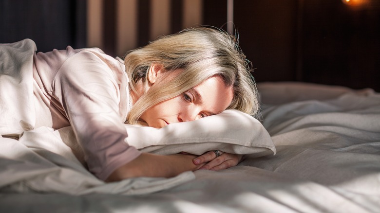 Woman in bed looking helpless