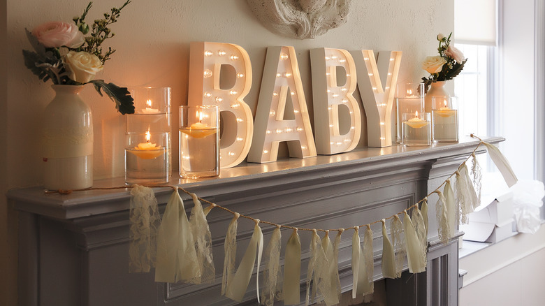 Gender neutral baby shower decorations around mantle