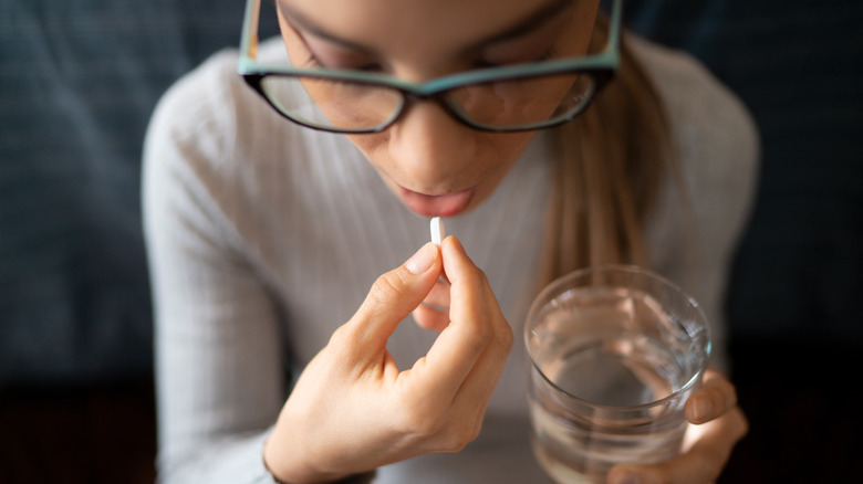 A woman taking a pill 