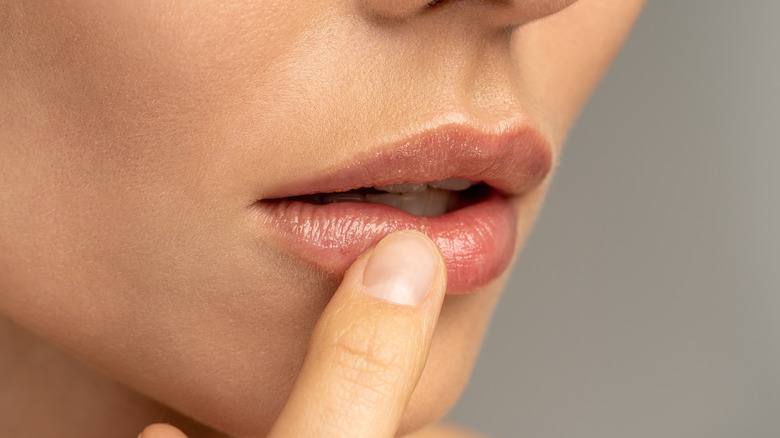 A woman touching her lip 