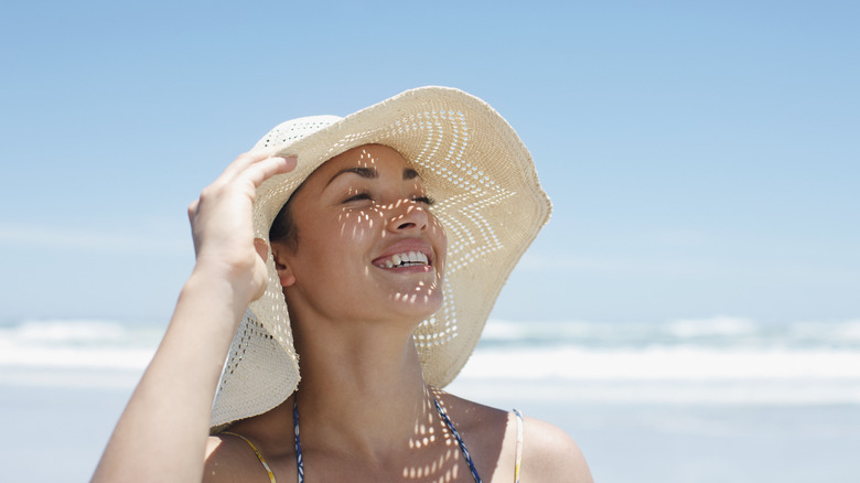 A woman smiling in a sun hat 