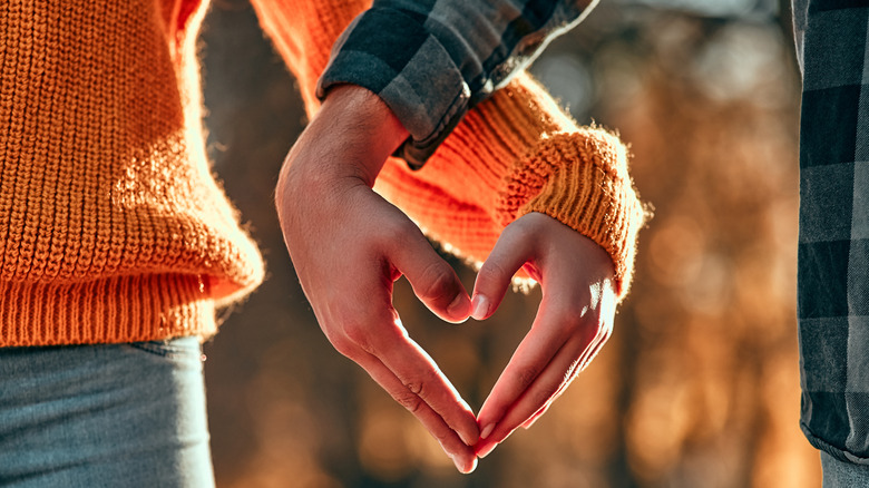 Couple making heart with their hands