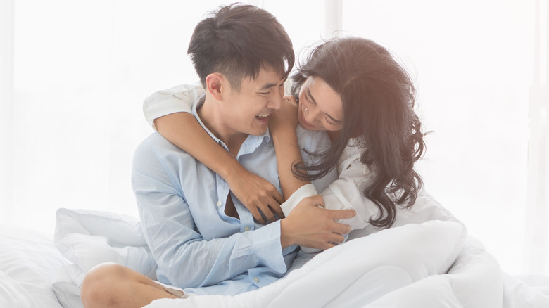 Couple holding each other in bed