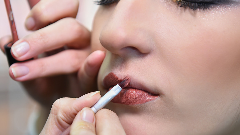 Makeup artist using lip brush