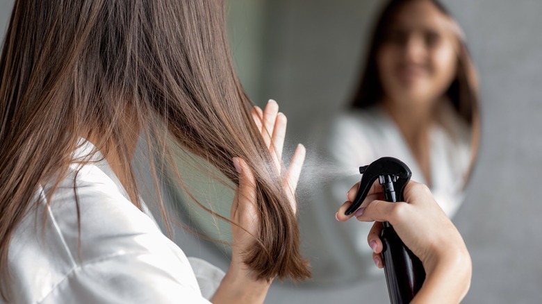 Woman spraying her hair