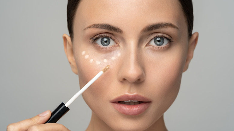 Woman applying concealer