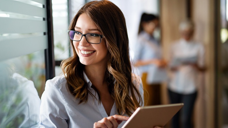 A woman smiling with an iPad