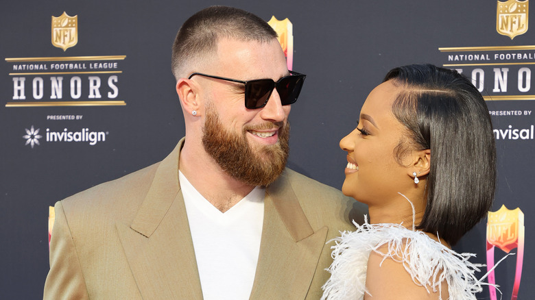 Travis Kelce and Kayla Nicole smiling at each other