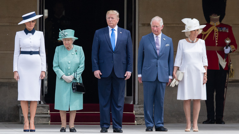 Donald Trump, Queen Elizabeth, Melania Trump, King Charles, and Queen Camilla standing outside