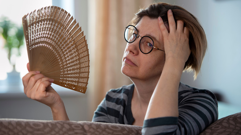 woman fanning herself during hot flash