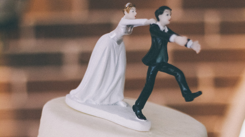 Cake-topper of bride chasing groom