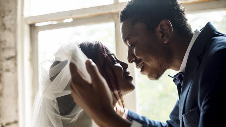 groom lifting bride's veil