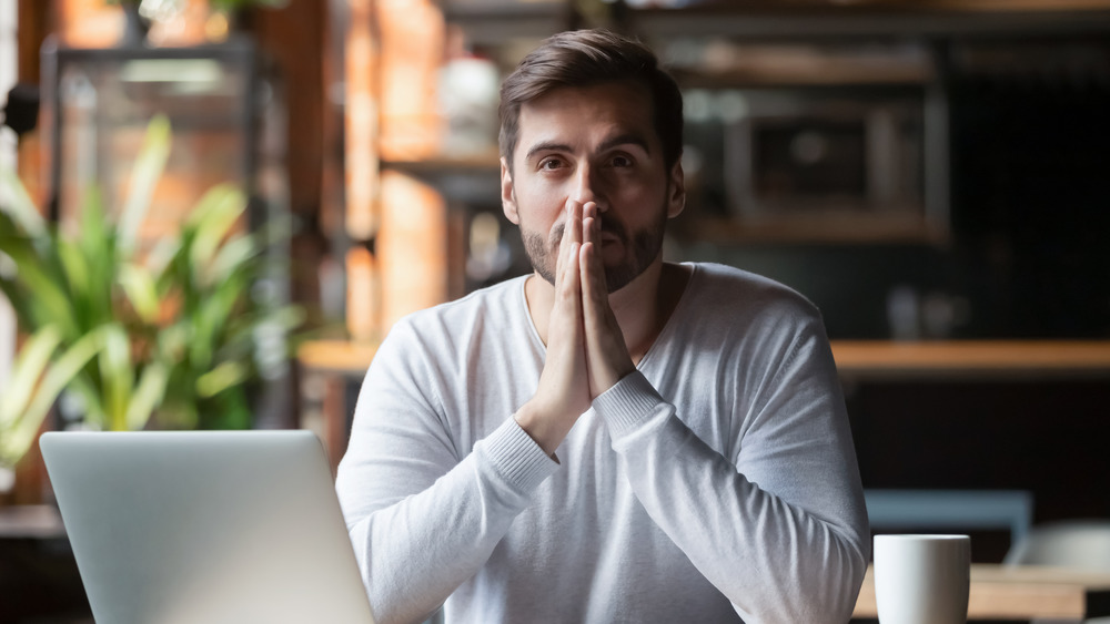 Worried man with hands together