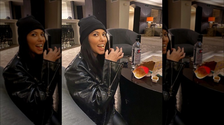 Kourtney Kardashian eating McDonalds french fries in a leather jacket