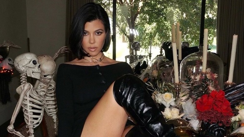 Kourtney Kardashian sitting on her Halloween decorated table