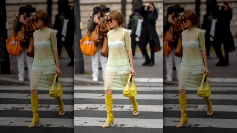 woman walking across street in yellow boots