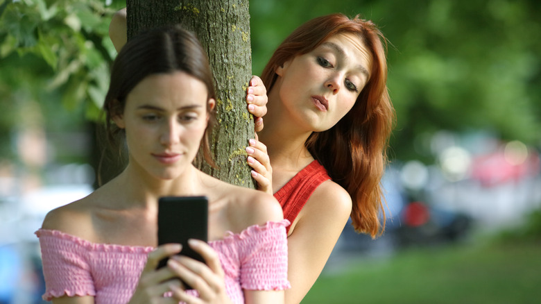 woman peering at girl's phone