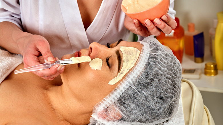 Woman being exfoliated by dermatologist