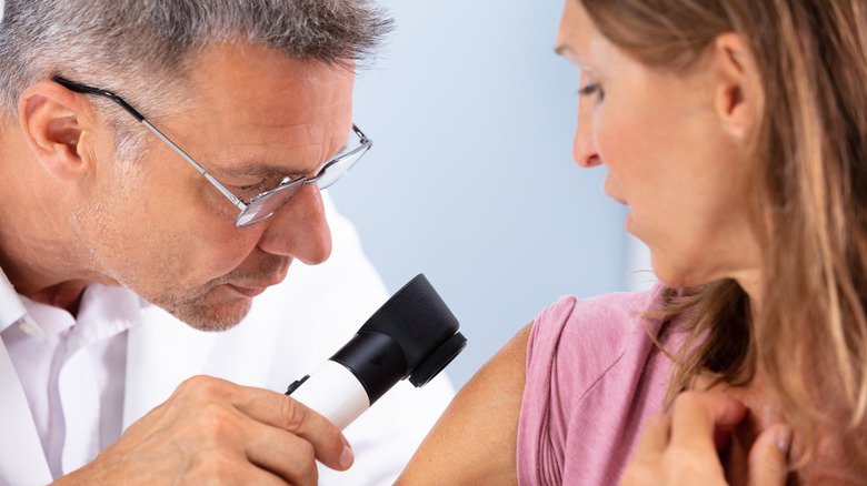 Woman being examined for signs of skin cancer